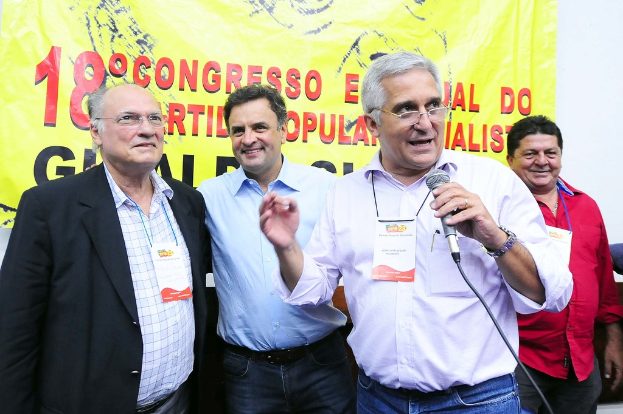 Ein Mann spricht in ein Mikrofon vor einem gelben Vorhang mit der Aufschrift "18-Grad-Kongress o."