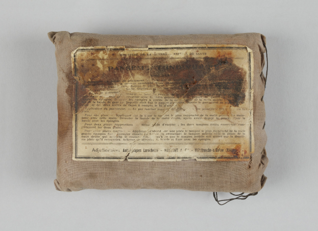 Kleiner Verbandkasten mit einer Papierzettel, auf der seine Inhalte aufgelistet sind.