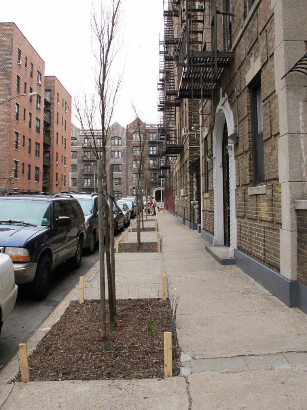 Eine spärlich besiedelte Stadtlandschaft mit wenigen Autos und Gebäuden im rechten Eck und einigen anderen Gebäuden im linken Eck.