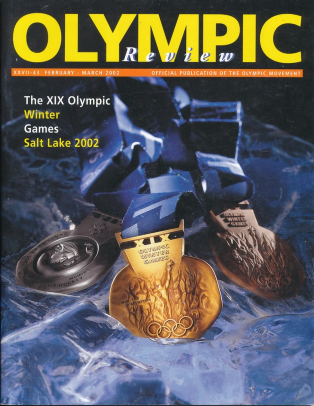 Ein Buch mit dem Titel "Olympische Revue" mit mehreren Medaillen in verschiedenen Größen und Farben und fettem Text auf dem Cover.