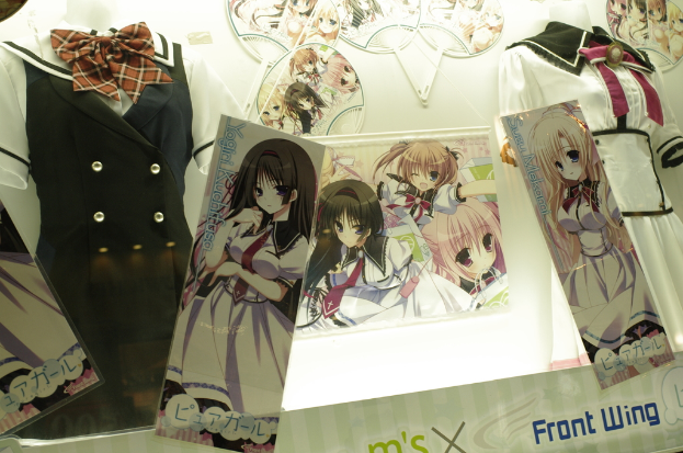 Schaufensterpuppen in verschiedenen Outfits mit Cartoons auf der Wand dahinter.