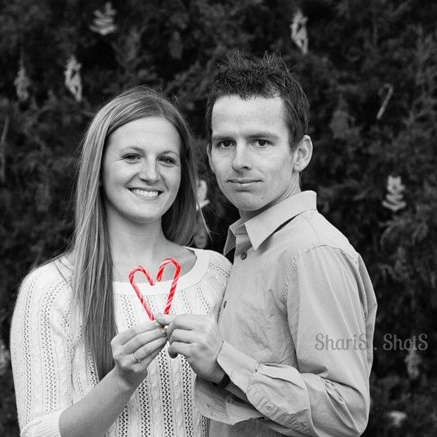 Ein Mann und eine Frau draußen mit zwei Strohhalmen in den Händen, mit einem Weihnachtsbaum im Hintergrund.