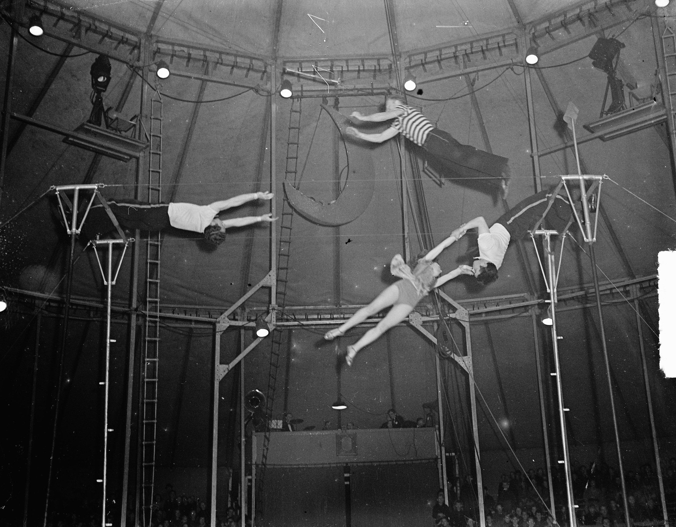 Schwarz-weiß-Foto von Akrobaten, die in einem Zirkuszelt auftreten