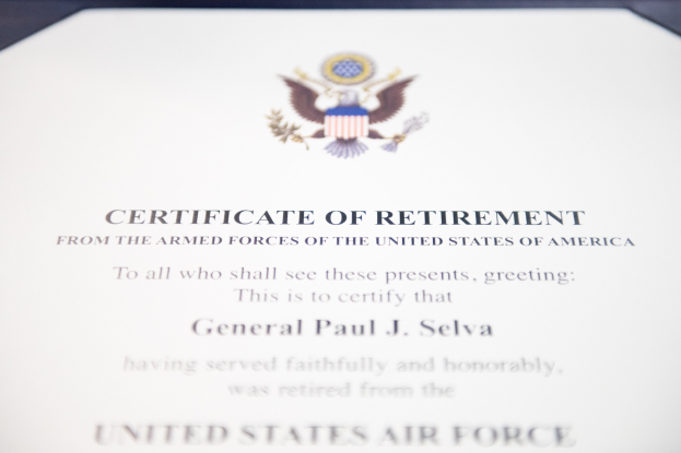 Rahmenurkunde zur Verabschiedung von der United States Air Force mit blauem Rand, zentralem Sternschild-Logo innerhalb eines Lorbeerkranzes und einer "Retirement"-Banderole, alles in Schwarz gedruckt.
