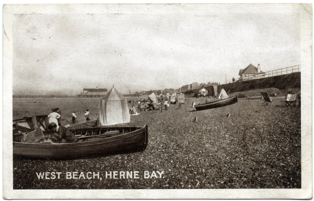 Schwarzes und wei├čes Foto von Menschen am Weststrand, Herne Bay, mit Booten im Vordergrund, H├Ąusern und einem Zaun im Hintergrund und Text unten.