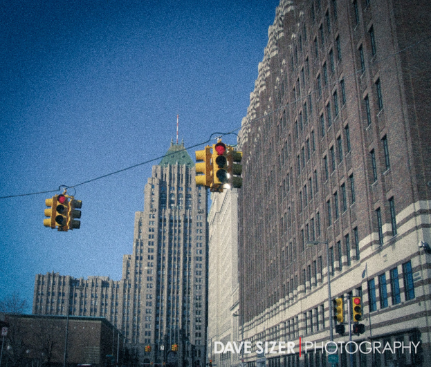 Mehrere Ampeln auf Masten vor Gebäuden montiert.