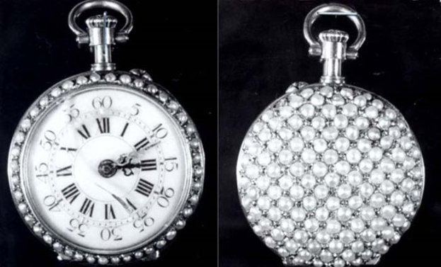 Eine silberne Taschenuhr mit einem runden Zifferblatt, das mit römischen Ziffern markiert ist, Diamanten, die in seine Oberfläche eingelassen sind, und einem schwarzen Hintergrund.