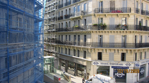 Ein großes Gebäude mit einem Geschäft im Erdgeschoss und Bauarbeiten auf der linken Seite.