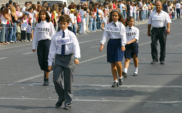 Eine Gruppe von Menschen, die auf einer Straße gehen und Abzeichen auf ihren Hemden tragen, umgeben von einer großen Menge.