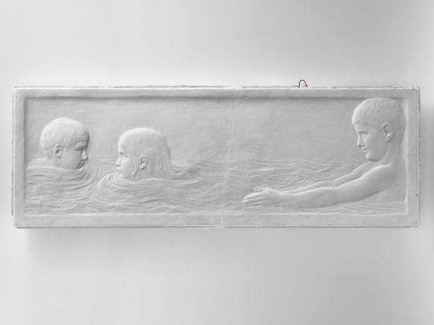 Drei Kinder beim Schwimmen in Wasser, mit einer Wand im Hintergrund, dargestellt auf einem Schwarz-Weiß-Foto.