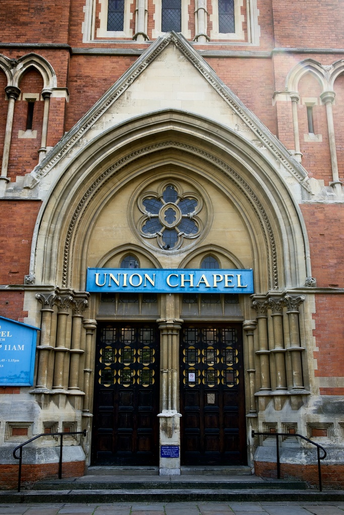 Eine große, historische Kirche in London mit zahlreichen Fenstern an ihren Wänden und zwei Türen am Eingang.