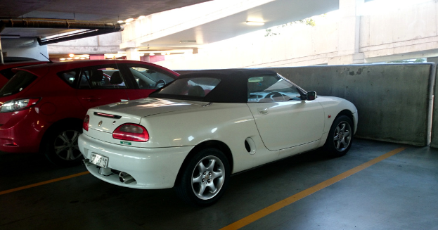 Autos in einem Keller mit einem Rohr am Dach und einem anderen Gebäude oben rechts.