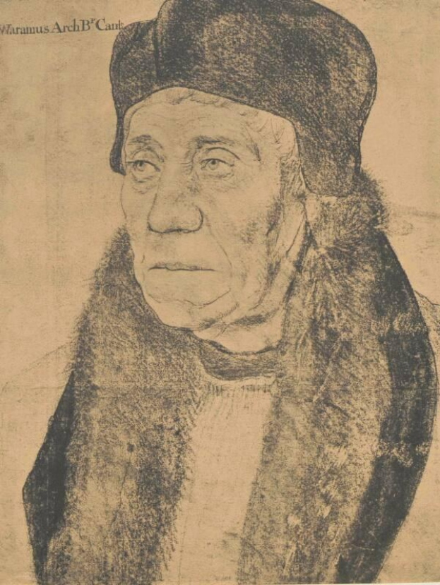 Eine ältere Frau mit schwarzem Hut und Nerzstola, die Hände faltend, mit Haaren im Dutt und sanftem Gesichtsausdruck, seitlich schauend.