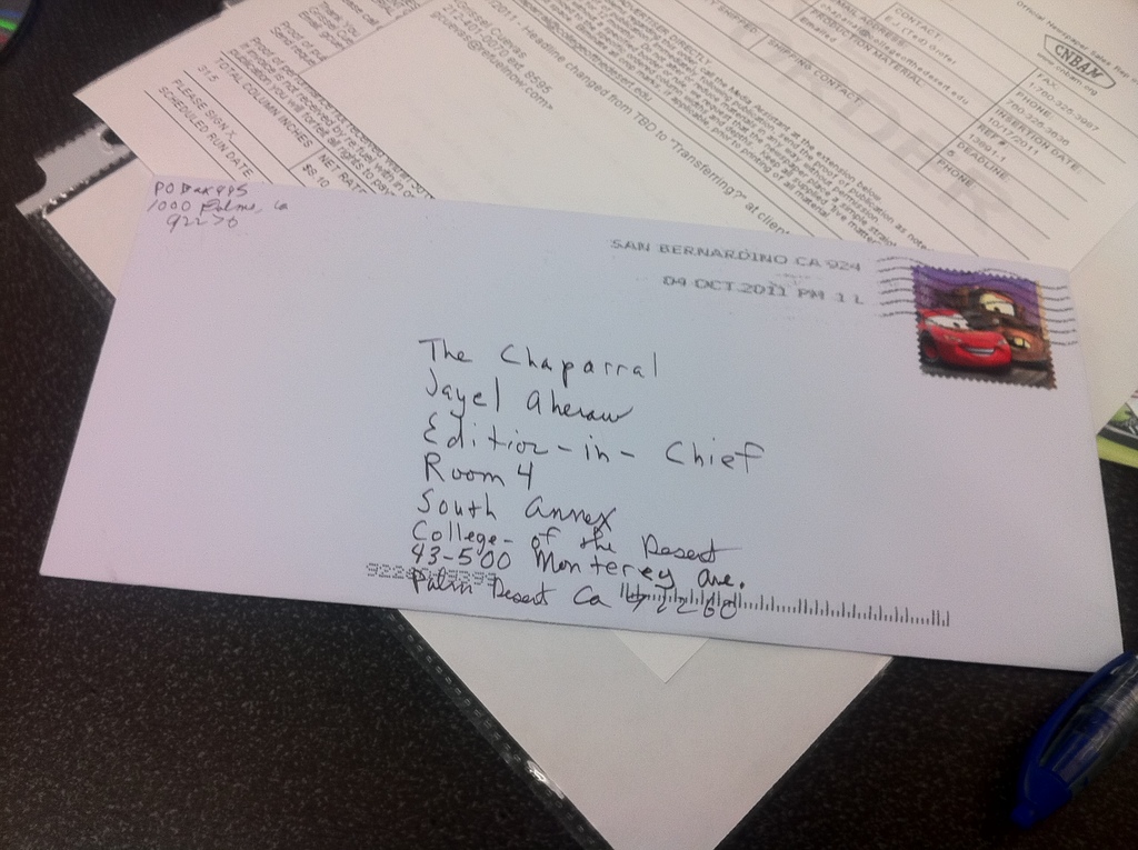 Ein Tisch mit Papier, einer Datei, einem Brief, einem Stift und einem nicht identifizierten Objekt darauf.