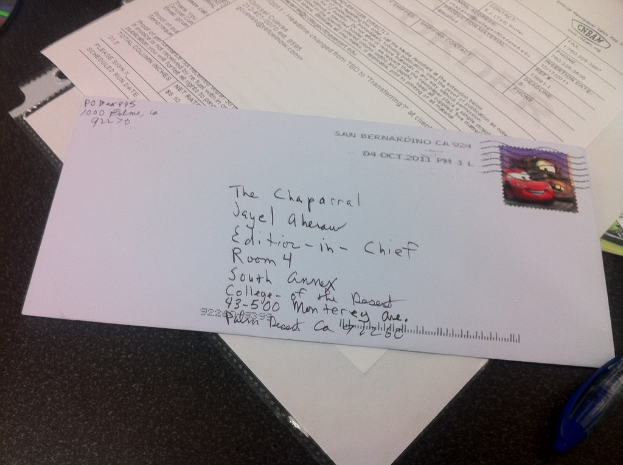 Ein Tisch mit Papier, einer Datei, einem Brief, einem Stift und einem nicht identifizierten Objekt darauf.