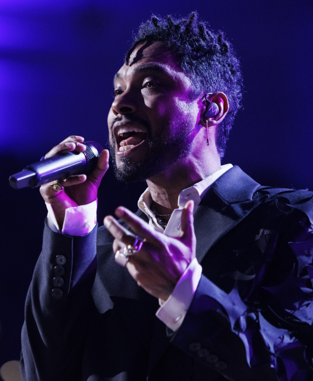 Ein Mann in einem schwarzen Anzug, der in ein Mikrofon singt, auf einem Konzert in der O2 Arena London.