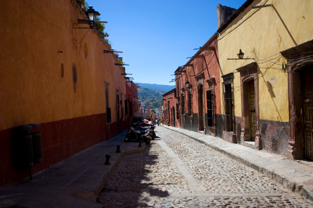 Eine leere Straße mit zahlreichen geparkten Fahrrädern, umgeben von mehreren Gebäuden, mit einem Gebäude prominent im Vordergrund.