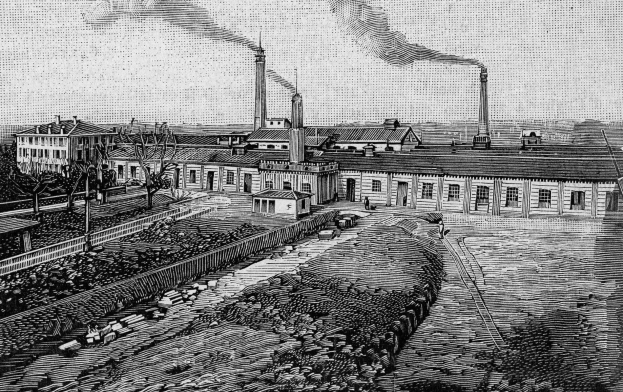 Schwarze und weiße Zeichnung einer Fabrik mit Rauch aus den Schornsteinen, umgeben von Gebäuden, Bäumen, Pflanzen, Pfählen und Bahnschienen, beschriftet mit "1892 - die Fabrik des Eisenerzes" unten.