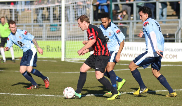 Eine Gruppe von Menschen, die mit einem Fu├čball auf einem Feld spielt.