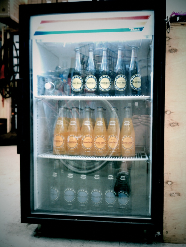 Ein Mini-Kühlschrank mit Flaschen mit Etiketten darin, mit einem unscharfen Hintergrund.