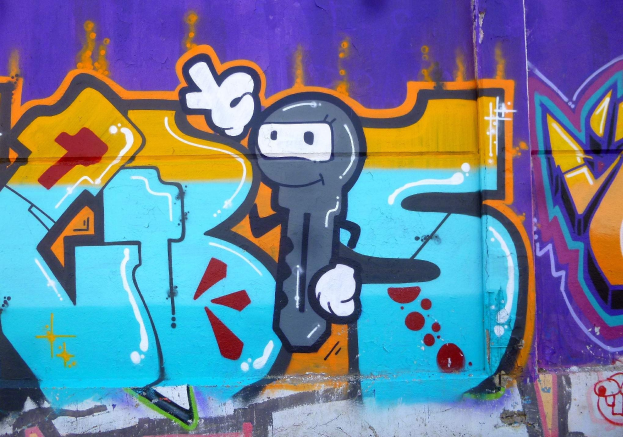 Eine lebendige und farbenfrohe Graffiti-geschmückte Wand mit einem hellen Cartoon-Charakter in verschiedenen Formen und Größen.