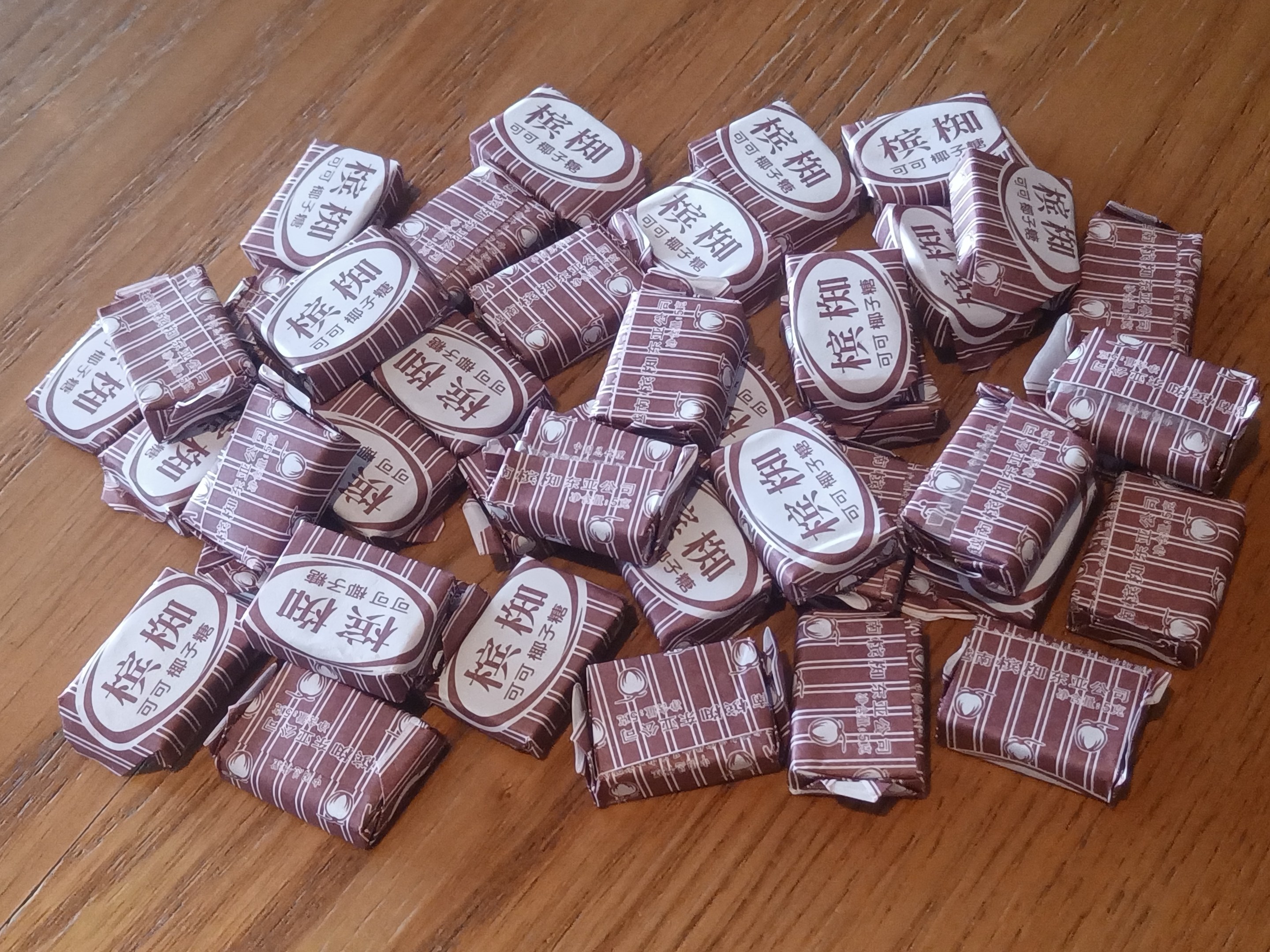 Ein Holztisch mit einem Haufen Schokoladen, jede mit Text markiert, der die Art der Süßigkeit angibt.