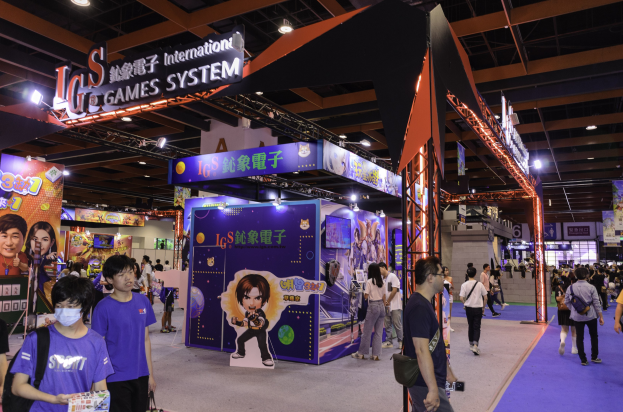 Eine Gruppe von Menschen, die durch einen Convention Hall auf einer Gaming-Messe in China gehen, einige tragen Taschen und halten Gegenstände, mit Schildern, Deckenleuchten und Teppichboden.