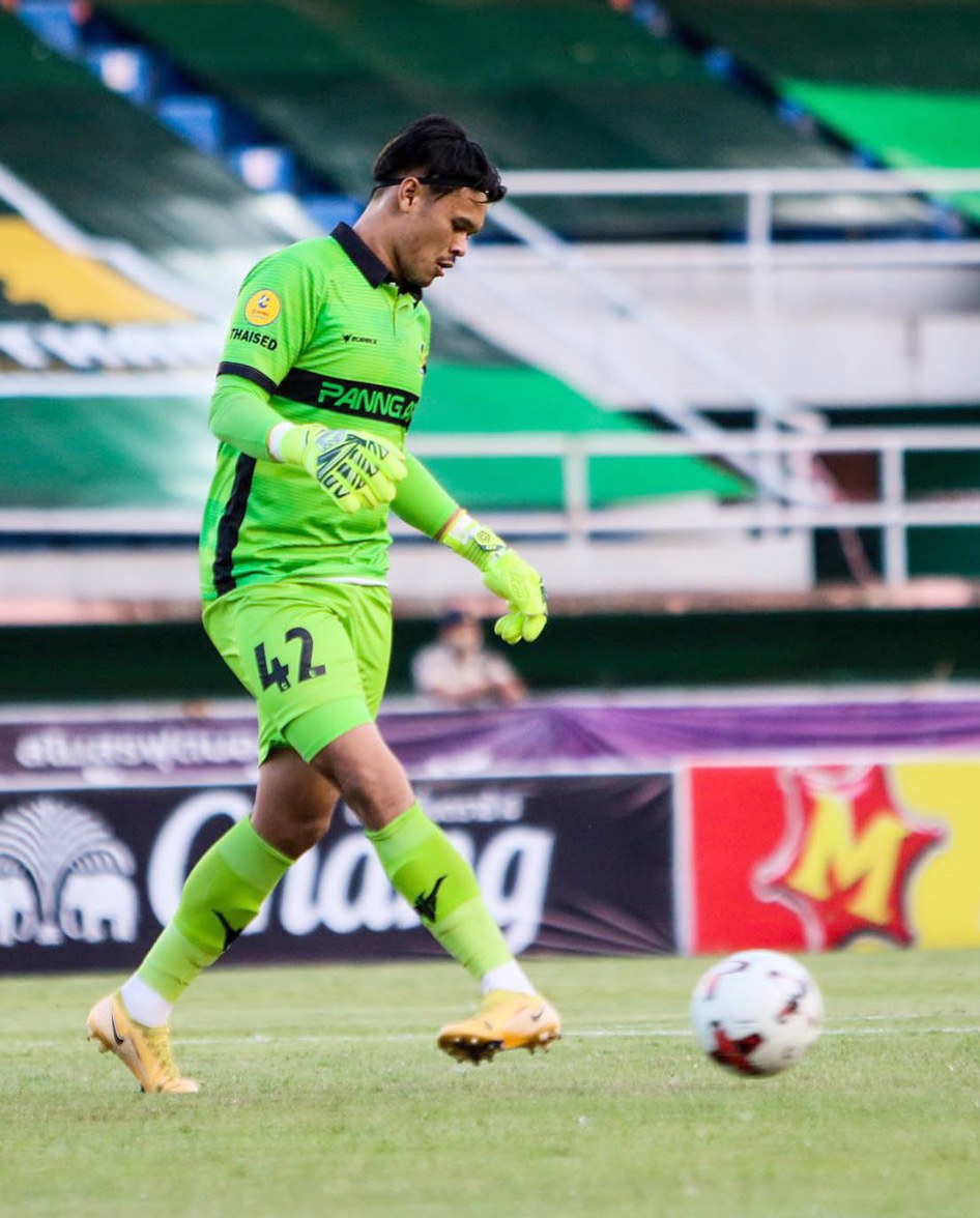 Ein Torwart in grüner Uniform kickt einen Fußball auf einem Rasenfeld in einem Stadion, mit Bannern im Hintergrund, die 'Chivas USA gegen Mexico City, 3-1, Copa Libertadores' lesen.