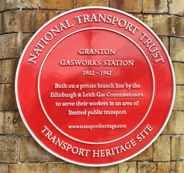 Rotes rundes Schild an einem Backsteingebäude mit "National Transport Trust"-Text.