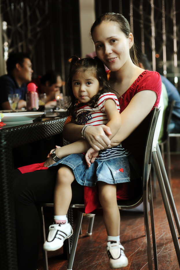 Eine Frau sitzt mit einem Baby auf dem Schoß, umgeben von mehreren Männern.