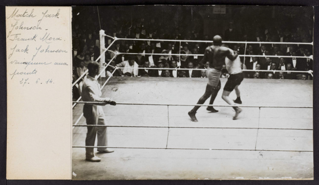 Schwarz-weiß-Foto von zwei Boxern im Ring mit einem Schiedsrichter links und Zuschauern im Hintergrund, betitelt mit "Jack Johnson vs Frank Morgan".
