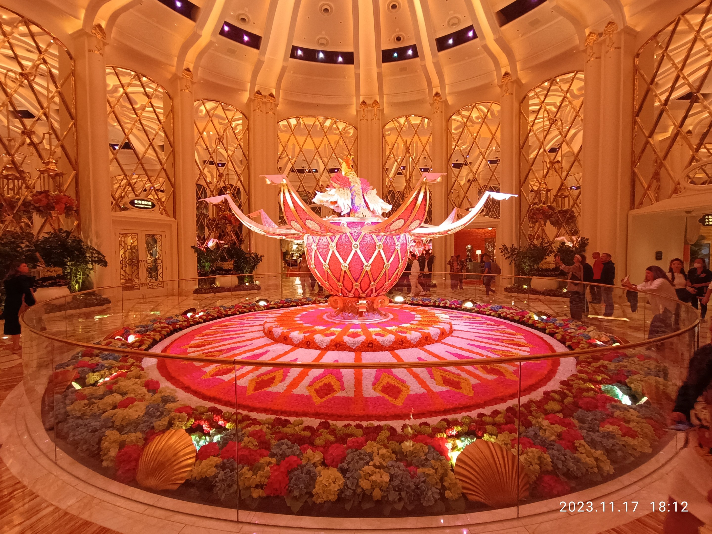 Das Bellagio Hotel und Casino in Las Vegas, Nevada, mit Menschen, dekorativen floralen Bodenmustern, Säulen und Lichtern, mit einem Wasserzeichen unten.