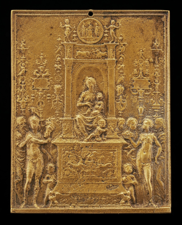Goldene Plakette mit detaillierter Skulptur einer Frau in einem langen Kleid und einem Mann in einem Anzug und Krawatte auf schwarzem Hintergrund, umrahmt von einem goldenen Rahmen.