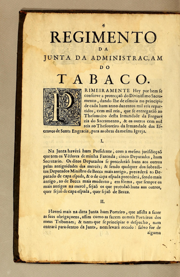 Old book titled "Regimento da Junta da Administracam do Tabaco" open to reveal text inside.