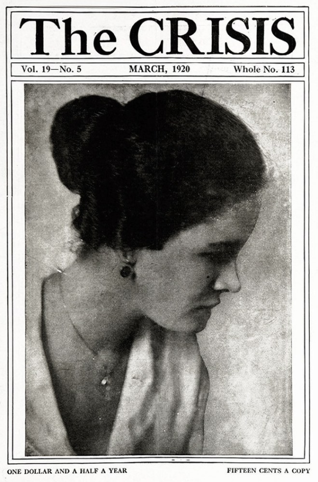 Schwarz-weiß-Porträt einer Frau auf dem Titelblatt einer Zeitschrift, die "Die Krise" trägt, in einem weißen Kleid mit einem gemusterten Schultertuch, das Haar zurückgekämmt, die Augen zur Seite gewandt, die Lippen leicht geöffnet.