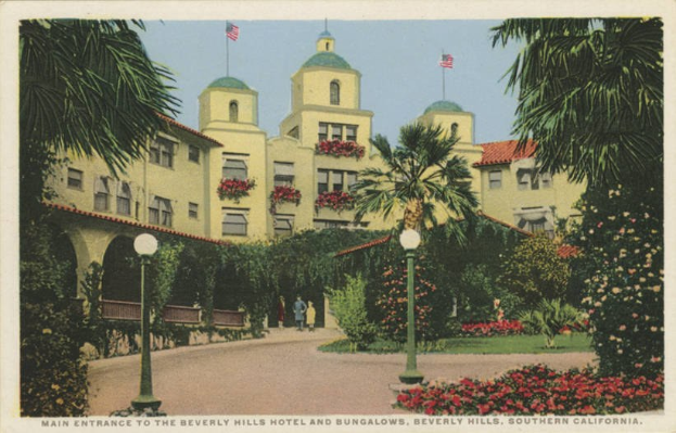 Postcard of the Beverly Hills Hotel and Bungalows in Southern California, showing the building with windows, trees, flowering plants, street poles, a pathway, people, flags, and a cloudy sky, with text at the bottom.
