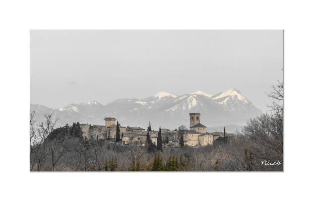 Eine Burg in der Mitte, mit Bäumen unten, Hügeln und Himmel im Hintergrund.