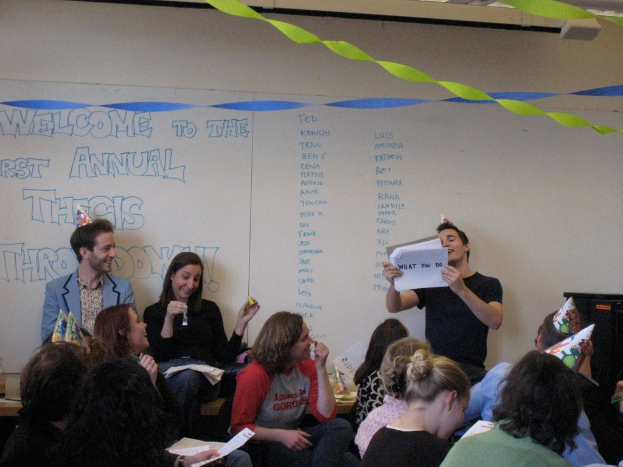 Eine Gruppe von Menschen feiert ihren ersten Jahrestag der Abschlussarbeit, mit Bändern geschmückt und einige tragen Mützen.