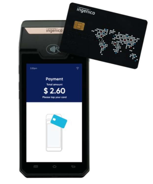 A modern Scotiabank ATM machine with a black and silver design, featuring a large display screen and control buttons, positioned in front of a light grey wall with framed pictures and the text "Scottish Bank" in the background.