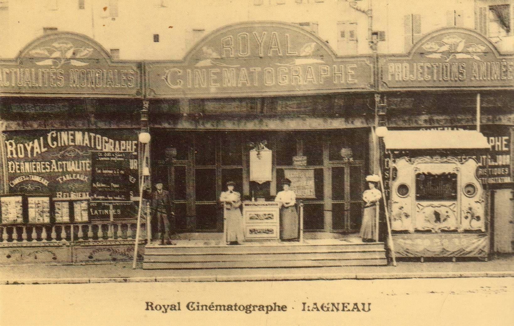 Schwarzes und weißes Foto des Royal Cinematographe in Ligneau, Frankreich, mit ein paar Menschen vor dem Gebäude, das mit Schildern und Lichtern geschmückt ist, und Text unten.