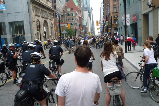 GebÃ¤ude säumen eine StraÃe, auf der einige Menschen Fahrrad fahren.