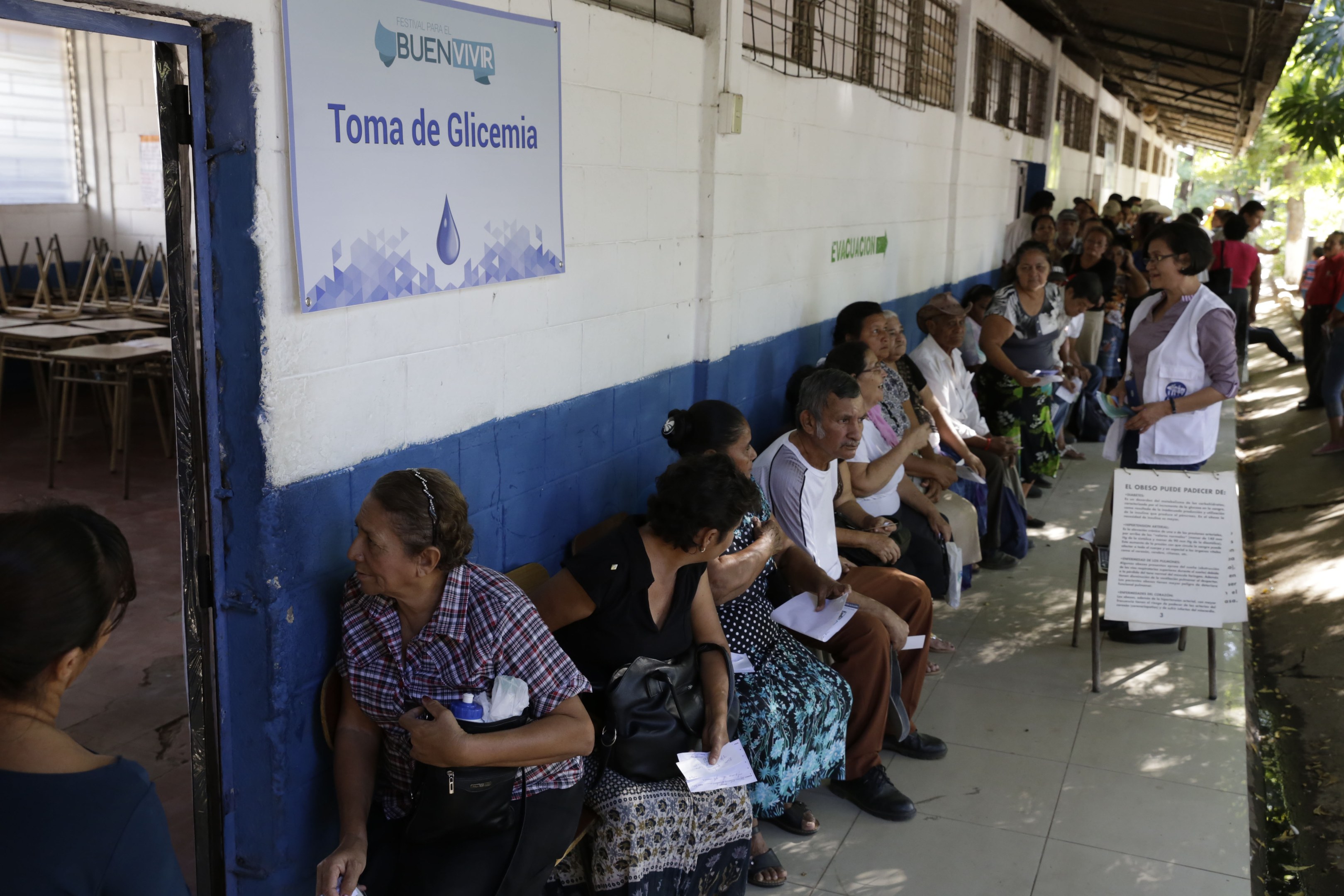 Menschen, die auf Bänken vor einem Gebäude sitzen und in einer Schlange stehen, um in einer Wahllokal in Guadalajara, Mexiko, ihre Stimmen abzugeben.