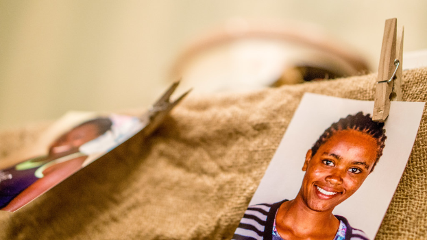 Auf einem Tisch befinden sich eine Klammer, ein Passfoto im Passformat und ein Stoffstück auf der rechten Seite, mit einem unscharfen Hintergrund und linker Seite.