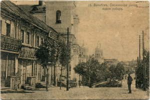 Black and white photo of a Moscow city street with buildings, trees, and pedestrians under a sky, featuring Cyrillic text at the top.