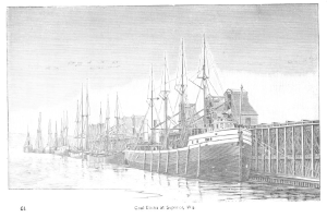 Schwarzes und weißes Foto von Kohledocks in Superior, Washington, mit Schiffen auf dem Wasser und einer Brücke auf der rechten Seite; Text unten.