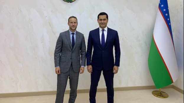 Two men in suits standing next to each other in front of a flag, smiling, identified as Bulgaria's Prime Minister and Foreign Minister meeting with the President of Bulgaria.